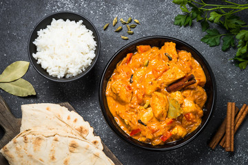 Chicken tikka masala with rice on black top view.