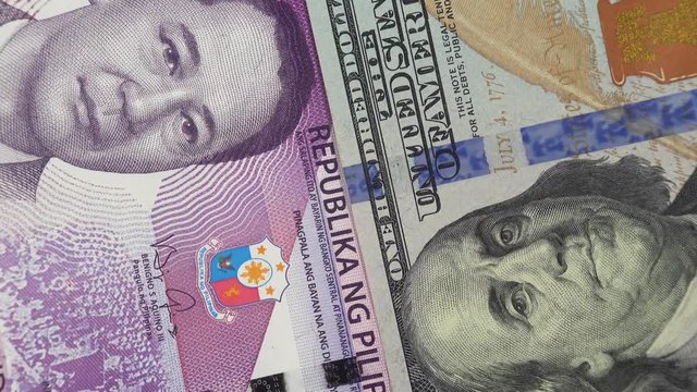 Philippine peso against US dollar bill rotating. Philippines and USA trade. 4K stock video footage