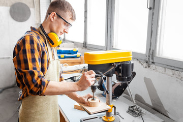 Obraz premium Professional craftsman working on drilling machine in the factory. Concept of technologies and career in the field of manual labor