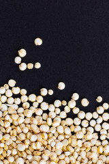 Seeds of uncooked Chenopodium quinoa, source of protein for vegetarians on black background, Macro shot with copy space for text and design