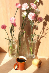 Spring flowers and a cup of coffee on a wooden background, the coziness of a new village house and a sunny bright morning