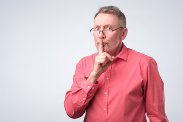 Man keeps finger on lips, tries to keep secret