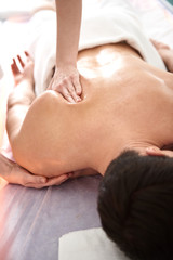 Obraz na płótnie Canvas Therapist making shoulder blade massage to man