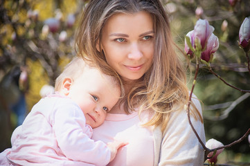 beautiful young mother with a baby in her arms is standing The concept of a happy family, motherhood