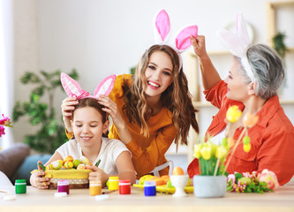 happy Easter! family grandmother, mother and child paint eggs and prepare for holiday.
