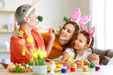happy Easter! family grandmother, mother and child paint eggs and prepare for holiday.