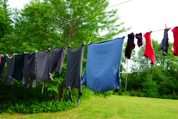 Many pieces of grey clothes dry on the clothesline.