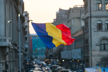 Romanian flag with Bucharest city background - obrazy, fototapety, plakaty