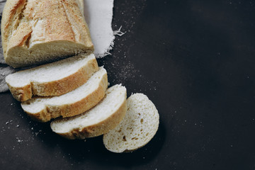 Bakery - fresh homemade sliced bread on black chalkboard background. Flat lay, top view, copy space for your text