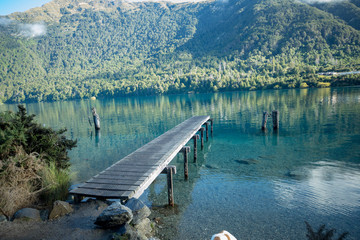 lake with mountains in background and a pier