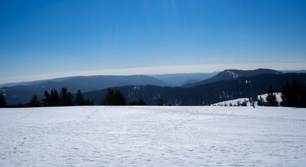 Beautiful panoramic view over snowy mountains in black forest - blue sky 