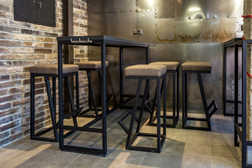 inside interior in modern pub sport bar with dark loft design style with red chairs