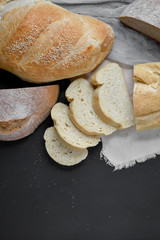 Bakery - fresh homemade sliced bread on black chalkboard background. Flat lay, top view, copy space for your text