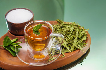 Stevia dry leaves and Stevia sweetener in clayware on mirror background. Stevia have Stevioside...
