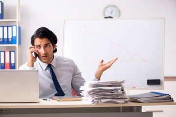 Young handsome financial speciaist in front of white board 