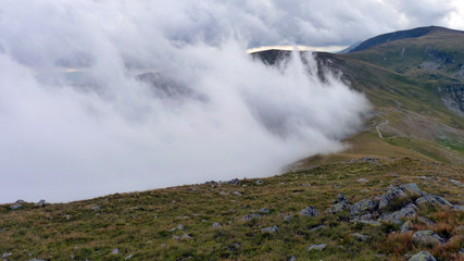 A wet day for the misty rocky mountains covered in snow and surrounded by big thick fog