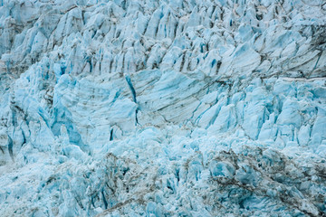 Glacial blues and dirt browns in fractured ice patterns on glacier in Drygalski Fjord, South Georgia, as a nature background
