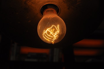 Incandescent light bulb exposed to filament with some dust, reflection on drum crash used as...