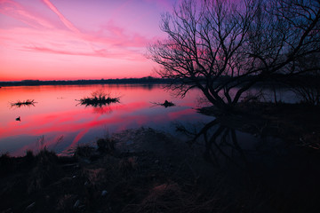 Fototapeta na wymiar Sonnenuntergang an einem See, ruhiges Gewässer, Weitwinkelaufnahme