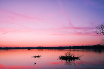 Obraz na płótnie Canvas Sonnenuntergang an einem See, ruhiges Gewässer, Weitwinkelaufnahme