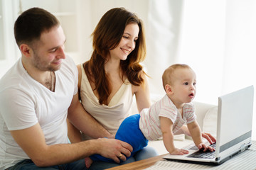 Loving parents sitting in living room at home laughing playing developing game with their little baby son. Childhood, parenthood, child development, togetherness, love, happiness concept
