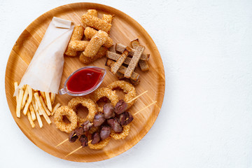 beer snacks set, bar table. restaurant, pub, oktoberfest food. french fries, breaded fried cheese sticks, onion rings, grilled chicken hearts, rye toasts. friday party atmosphere, craft brewery