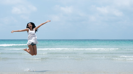 Fototapeta na wymiar Beautiful young Asian woman are jumping and show hand in to sky relaxing on beach on summer holidays vacations. Concept freedom, Lifestyle, tourism, holiday. with copy space