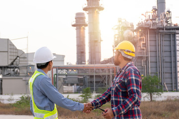 Engineers male shake hands at power plant. Energy power station area Sunset time interval. Concept...
