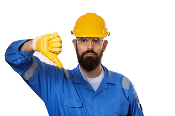 Portrait architect builder in transparent safety glasses. Bearded man worker in hard hat with angry face showing dislike with thumbs down, rejection concept over white background.
