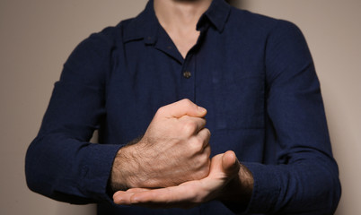 Man showing word CRUCIFY in sign language on color background, closeup