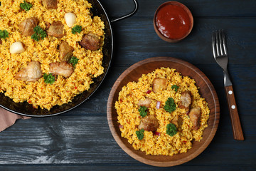Flat lay composition with rice pilaf and meat on wooden background