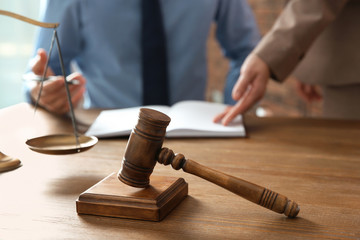 Notaries working at table in office, focus on judge gavel. Law and justice concept