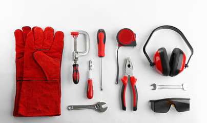 Flat lay composition with construction tools and safety equipment on white background