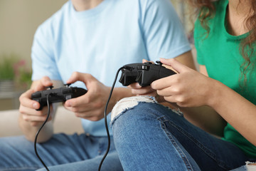 Young couple playing video games at home, closeup