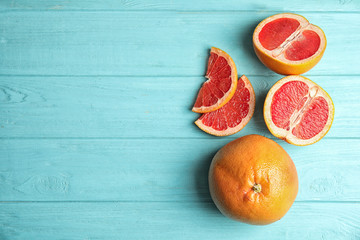 Fresh tasty grapefruits on color background, top view with space for text