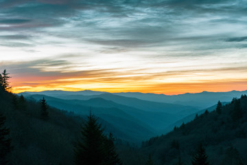 Orange glow from the sun illuminates the sky over the Great Smoky Mountains