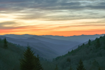 Orange glow from the sun illuminates the sky over the Great Smoky Mountains