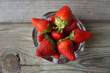 Summer berries in a glass bowl on the old wood background. Summer berries.