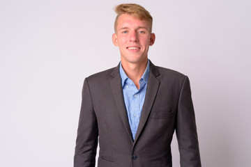 Happy young blonde businessman with suit smiling