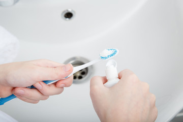 morning hygiene. Child brush teeth. Bath preparation. White interior of bathroom. Toothbrush and soap dispenser. Details of bathroom