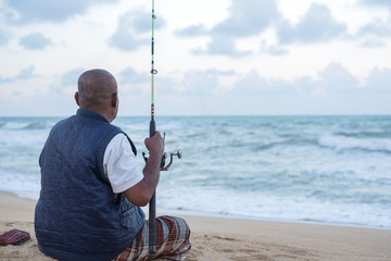 Senior man fishing at open sea. Thai people lifestyle.