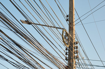 Messy wires attached to the electric pole in Thailand. The chaos of cables.