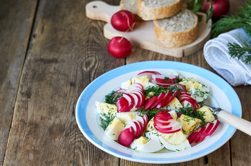 Fototapeta na wymiar Vegetable salad with radishes, dill and eggs on a wooden background
