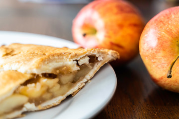 Piece of Apple pie with cracked crust and apples