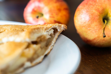 Piece of Apple pie with cracked crust and apples