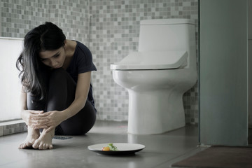 Anorexia woman sits with salad in the bathroom - obrazy, fototapety, plakaty