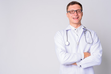 Portrait of happy young man doctor smiling with arms crossed