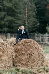Naklejka na ściany i meble Wedding photo shoot at the stables with hay. Beautiful couple, European wedding.