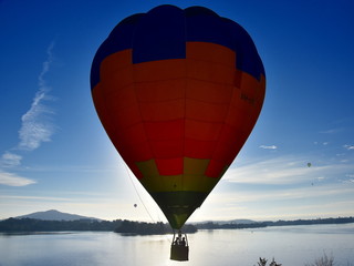 Canberra, Australia - March 10, 2019. Hot air balloon flying in the air above Lake Burley Griffin, as part of the Balloon Spectacular Festival in Canberra.