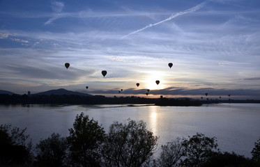 Hot air balloons flying in the air above Lake Burley Griffin, as part of the Balloon Spectacular Festival in Canberra.